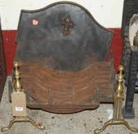 Lot 1145 - A cast iron fire grate raised on pair of brass...