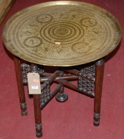 Lot 1213 - An Eastern engraved brass topped benares table...