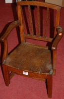 Lot 1231 - A 19th century child's elm panelled seat elbow...