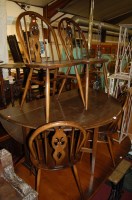 Lot 1255 - An Ercol dark elm drop leaf kitchen table with...