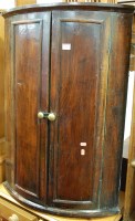 Lot 1444 - A 19th century oak two door bowfront hanging...