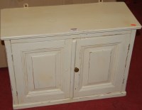 Lot 1436 - A small cream painted pine two door hanging...
