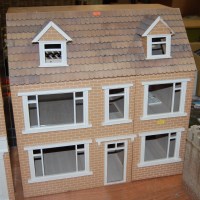 Lot 1610 - A modern wooden three-storey childs dolls house