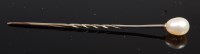 Lot 413 - A white metal and pearl topped stick pin in...