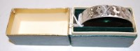 Lot 472 - A 1970s silver bangle having a floral engraved...
