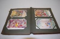 Lot 544 - A postcard album and contents, to include...