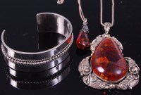 Lot 401 - A large teardrop shaped amber pendant, within...