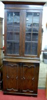 Lot 1105 - A 1930s oak cabinet bookcase, having glazed...