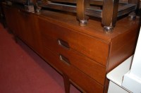 Lot 1213 - A 1970s teak long sideboard, having central...