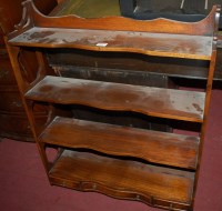 Lot 1231 - A mahogany four tier wall shelf, on pierced...