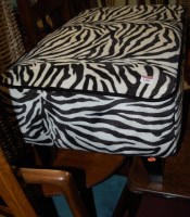 Lot 1283 - A modern footstool, upholstered in black and...