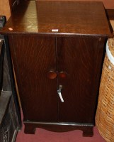 Lot 1338 - A mid 20th century oak two-door record cabinet...