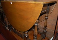 Lot 1212 - A reproduction oak gateleg table, the hinged...