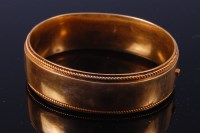 Lot 376 - A ladies yellow metal hinged bangle, of plain...