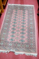 Lot 1149 - A Persian woollen Bokhara having a pink ground,...