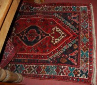 Lot 1449 - A Persian woollen red ground rug, having...