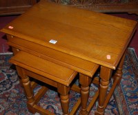 Lot 1456 - A moulded oak nest of three occasional tables,...