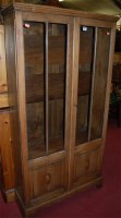 Lot 1232 - A 1930s oak double door glazed bookcase, w.79cm