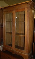 Lot 1448 - An Art Nouveau oak double door glazed bookcase,...