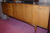 Lot 1449 - A 1960s teak long sideboard, having four...