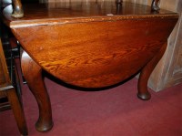 Lot 1453 - A heavy oak dropleaf dining table; together...
