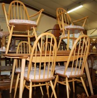 Lot 1267 - An Ercol light elm dining suite, comprising...