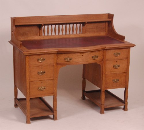 Lot 329 - An Arts & Crafts oak kneehole writing desk by...