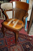 Lot 1271 - A 1930s oak slatback elbow chair, having tan...