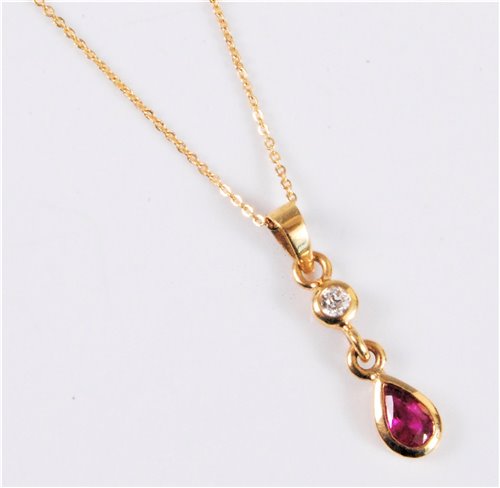 Lot 2581 - An 18ct ruby and diamond pendant, the pear...