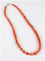 Lot 2570 - A coral bead necklace, the barrel shaped beads...