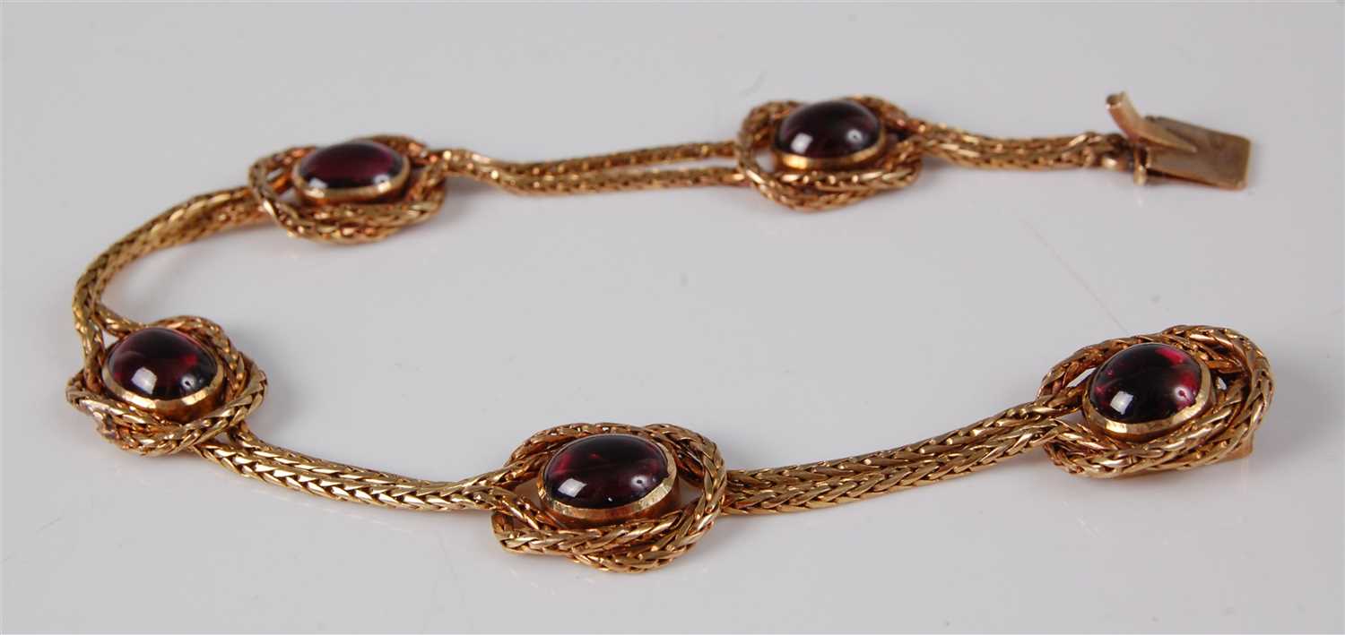 Lot 1176 - A yellow metal and cabochon garnet set...
