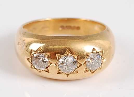 Lot 1192 - An 18ct yellow gold Gypsy style three stone...