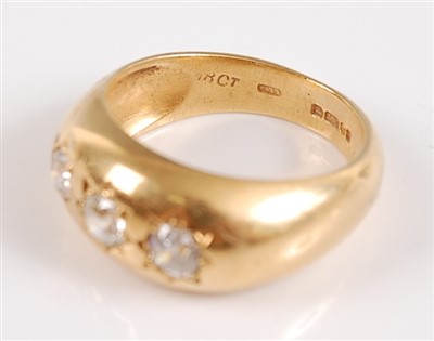 Lot 1192 - An 18ct yellow gold Gypsy style three stone...