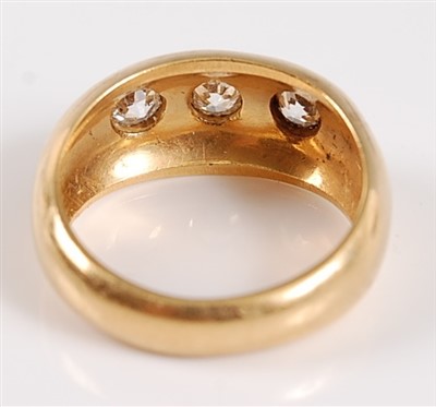 Lot 1192 - An 18ct yellow gold Gypsy style three stone...