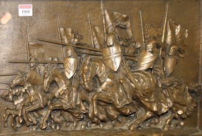 Lot 1068 - A bronzed composition plaque featuring...