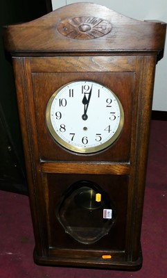 Lot 1158 - A 1920s oak droptrunk wall clock, h.75cm