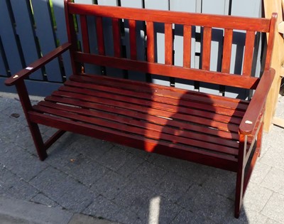 Lot 1182 - A stained wood and slatted two-seater garden...