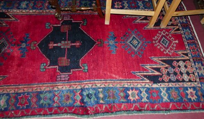 Lot 1198 - A Turkish woollen red ground rug, having...