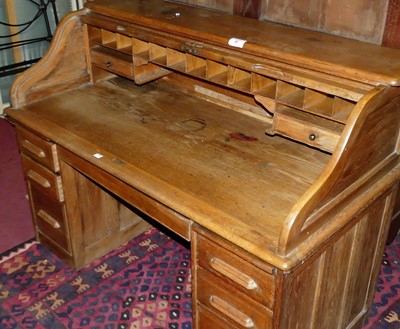 Lot 1208 - An early 20th century oak roll top kneehole...