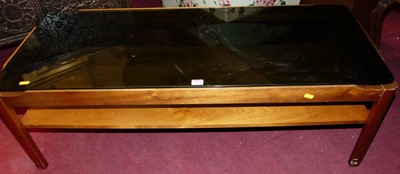 Lot 1523 - A 1970s teak and smoky glass inset two-tier...