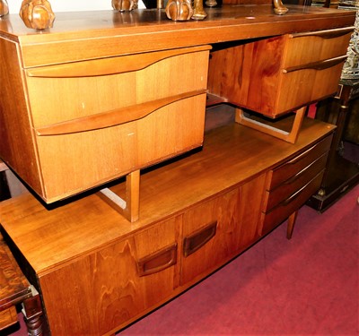 Lot 1485 - A 1960s teak long kneehole mirror back...