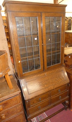 Lot 1360 - A 1920s oak bureau bookcase, having twin lead...