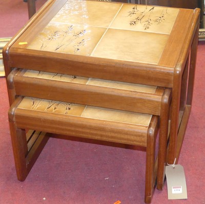 Lot 1394 - A 1970s teak and tiled top inset nest of three...