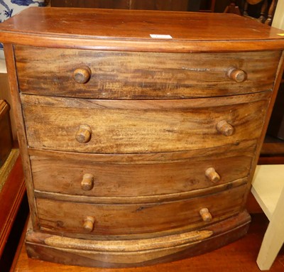 Lot 1266 - A hardwood bowfront table top chest of four...