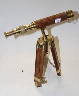 Lot 556 - A reproduction lacquered brass and teak...