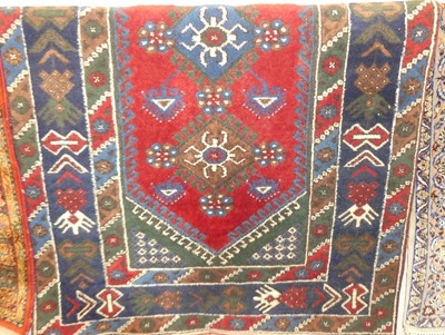 Lot 1182 - A Turkish woollen red and blue ground rug, the...
