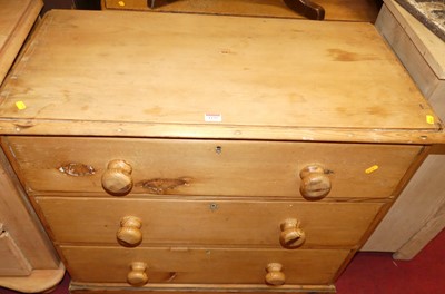 Lot 1235 - A rustic pine low chest of three long drawers,...