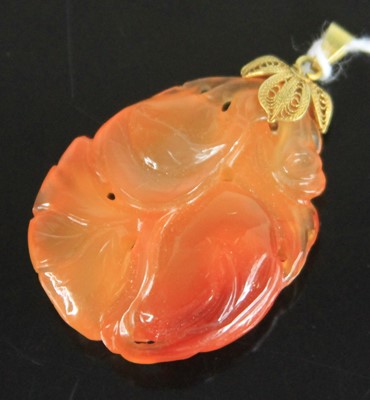 Lot 371 - A Chinese carved carnelian pendant, on yellow...