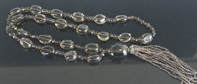 Lot 375 - A beaded and faceted smoky glass long necklace,...