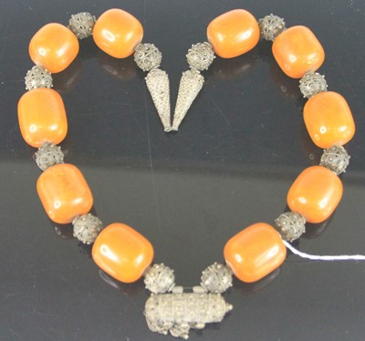 Lot 381 - An African faux amber and filigree worked...